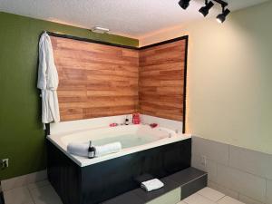 a bath tub in a bathroom with green walls at Lafayette Inn & Suites in Indianapolis