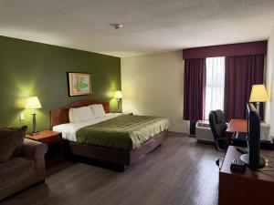 a hotel room with a bed and a couch at Lafayette Inn & Suites in Indianapolis