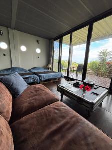 a living room with two beds and a table at Container Suite 75 in Nago