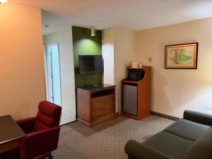 a hotel room with a couch and a tv at Lafayette Inn & Suites in Indianapolis