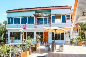 a house with a patio with an umbrella and chairs at TUBURAN Poolside in Nagsulang