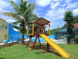 a playground with a yellow slide in a yard at Rede Elevare Bella Vista in Florianópolis