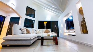 a living room with a white couch and a table at Villa Kynoa 4 étoiles in Saint-François