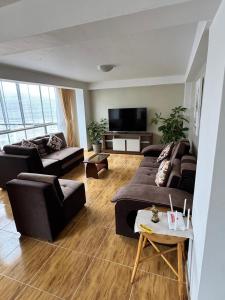 a living room with two couches and a flat screen tv at Santa Ana Home Cusco in Cusco