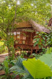a bamboo house with a thatched roof in a forest at Wonderland in Siquijor
