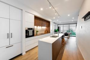 a kitchen with white cabinets and a kitchen island at Oak & Ivy on Windsor in Williamstown