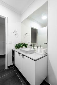 a white bathroom with two sinks and a mirror at Oak & Ivy on Windsor in Williamstown +24 photos