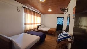 a small room with two beds and a couch at Absolute Breeze by cherins in Matara