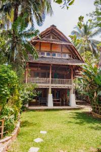 a house with a grass yard in front of it at Villa Monyet Java in Batukaras