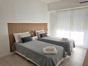 a bedroom with two beds with towels on them at Luminoso y cálido atardecer in Ramos Mejía