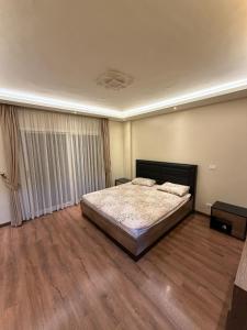 a bedroom with a bed and a wooden floor at Modern 4BR 3Bath Stylish Spacious in Madinaty