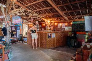 a woman standing at a bar in a restaurant at Wonderland in Siquijor