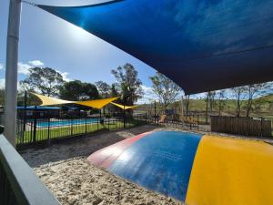 a swimming pool in a park with a blue canopy at Bonnie Doon Caravan Park in Bonnie Doon +11 photos