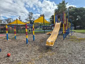 a playground with a slide in a park at Bonnie Doon Caravan Park in Bonnie Doon