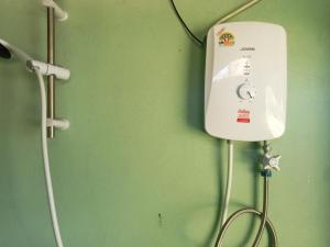 a hospital room with a white phone on a green wall at Phathokcamping in Ban Phathok