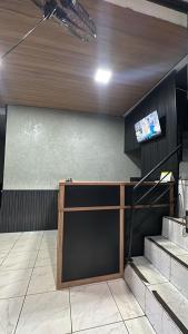 a room with a counter and a tv on a wall at Pousada Amizade in Água Boa