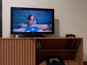 a flat screen tv sitting on top of a wooden stand at Suite ejecutiva con Parqueo Privado in Latacunga