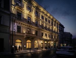 um grande edifício numa rua da cidade à noite em COSMOPOLITAN Hotel Prague em Praga