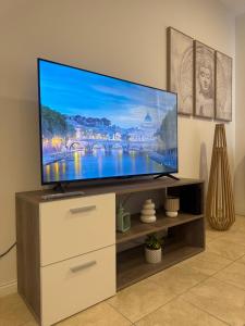 a flat screen tv sitting on a stand in a living room at Campana Suites Becerra in Campana