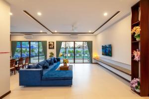 a living room with a blue couch at Blanc Smith Private Villa in Siem Reap