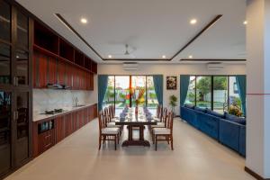 a dining room with a long table and chairs at Blanc Smith Private Villa in Siem Reap