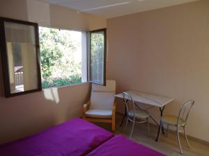 1 dormitorio con 1 cama, mesa y sillas en Delaporte, en Béziers