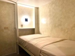 a small bed in a small room with a window at Poddwell Siquijor in San Juan