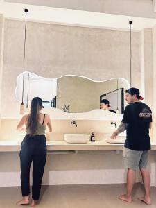 a man and woman standing in front of a bathroom mirror at Poddwell Siquijor in San Juan