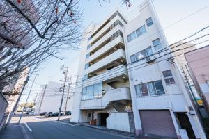 a white building on the side of a street at Minato Marine Stay in Nagoya