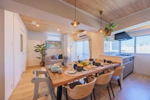 a dining room and kitchen with a large wooden table and chairs at Minato Marine Stay in Nagoya