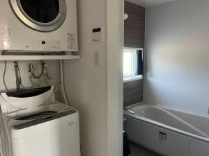 a small kitchen with a washing machine and a tub at Yuimaru - Vacation STAY 43049v in Bora