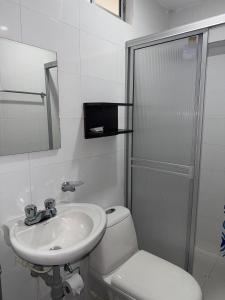 a white bathroom with a sink and a toilet at Nacar Boutique hotel in Valledupar
