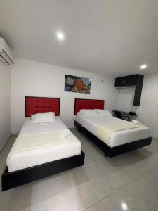 two beds in a room with two beds sidx sidx sidx sidx at Nacar Boutique hotel in Valledupar +20 photos