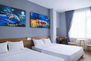 a hotel room with two beds and a table at Hoa Dã Qùy Hotel 2 in Pleiku