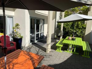 a green table and an umbrella on a patio at YHA Nelson - Backpackers in Nelson