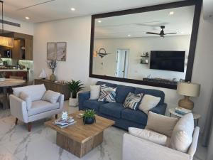 ein Wohnzimmer mit einem blauen Sofa und Stühlen in der Unterkunft Encanto de Cortes in Playa Encanto