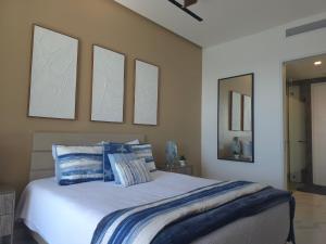 ein Schlafzimmer mit einem Bett mit blau-weißen Kissen in der Unterkunft Encanto de Cortes in Playa Encanto + 26 Fotos