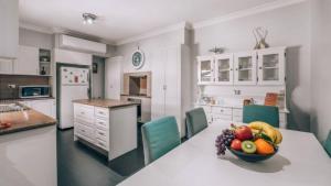a kitchen with a table with a bowl of fruit on it at Family Cottage in Bendigo