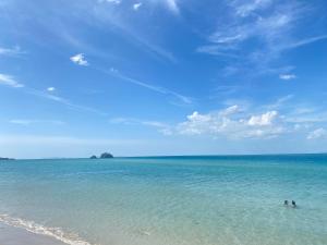 two people swimming in the water on a beach at Lantara resort in Ko Lanta