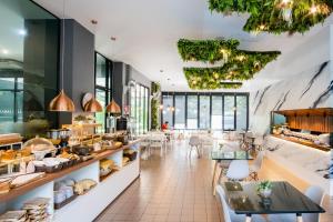 a restaurant with tables and chairs and a bakery at Tamsabai hotel in Nakhon Sawan
