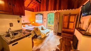a kitchen with a sink and a bed in a room at Chalés Lua de Mel in Monte Verde