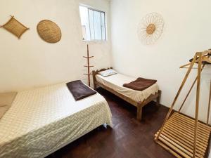 a room with two beds and a window at CasaDePretaPelo in Salvador