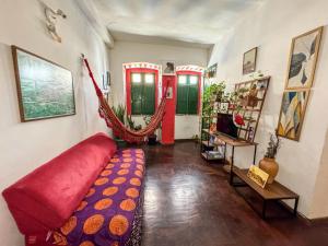 a living room with a red couch and a red door at CasaDePretaPelo in Salvador