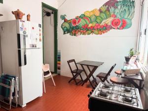 a kitchen with a refrigerator and a table with chairs at CasaDePretaPelo in Salvador