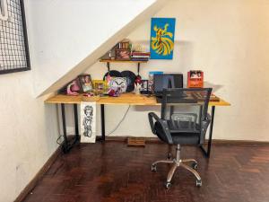 a desk with a computer and a chair in a room at CasaDePretaPelo in Salvador