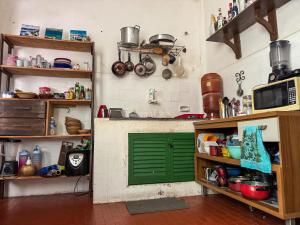 a kitchen with a green door in a room at CasaDePretaPelo in Salvador