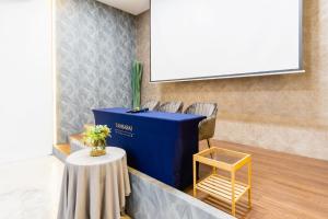 a meeting room with a table and a projector screen at Tamsabai hotel in Nakhon Sawan