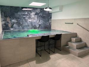 a swimming pool in a bathroom with stools around it at Costa Relax - 5 in Arroyo