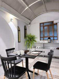 a dining room with a black table and chairs at Posada Del Corregidor in Cajamarca