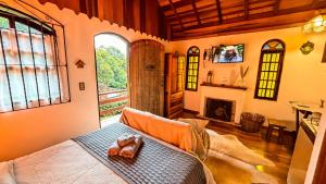 a living room with a bed and a fireplace at Chalés Lua de Mel in Monte Verde